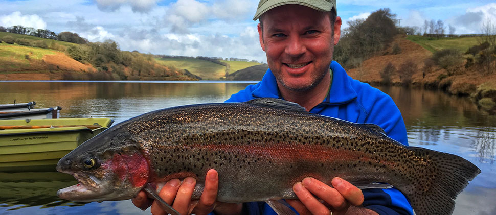 Man Smiling Whilst Holding A Fish