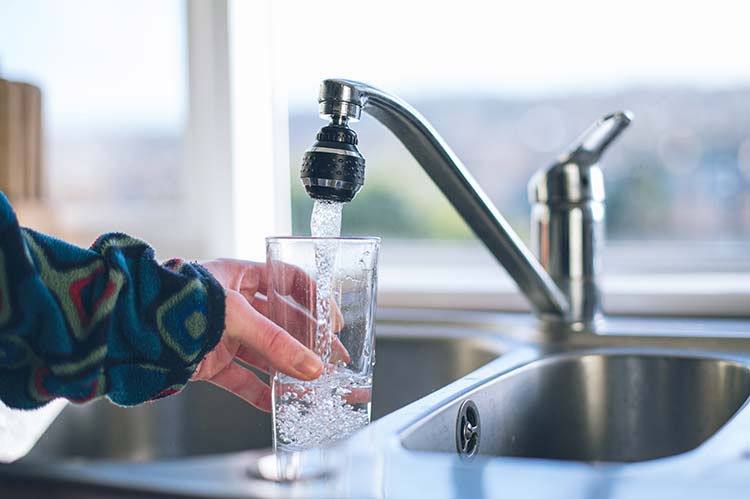 Customer filling up a glass from a kitchen tap