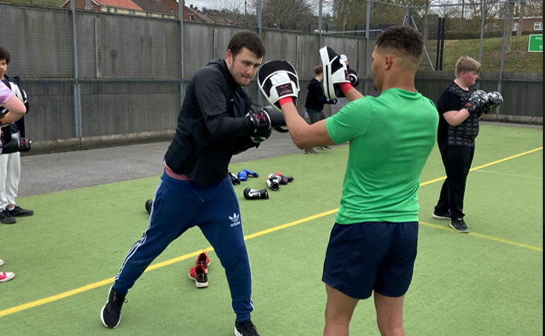 Members practicing boxing at the grassroots boxing club.